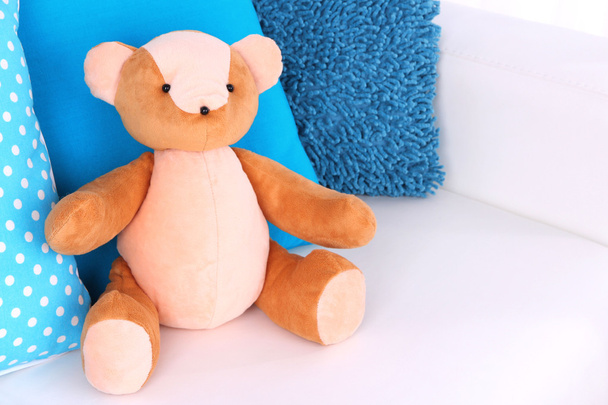 Bear toy with pillows on sofa - Fotó, kép