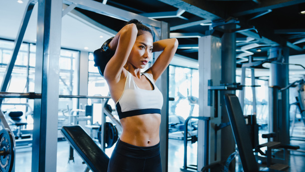 Beautiful young Asia lady exercise doing lifting barbell fat burning workout in fitness class. Athlete with six pack, Sportswoman recreational activity, functional training, healthy lifestyle concept. - Photo, Image