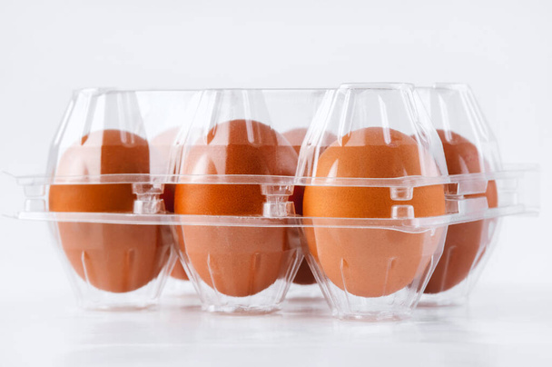 Brown chicken eggs transparent egg packaging tray front view, side view  on white background.6 pieces brown eggs. - Foto, afbeelding
