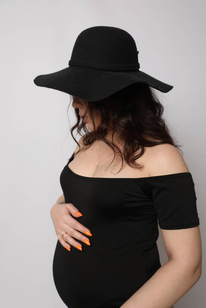 Красива молода вагітна жінка позує в студії
 - Фото, зображення