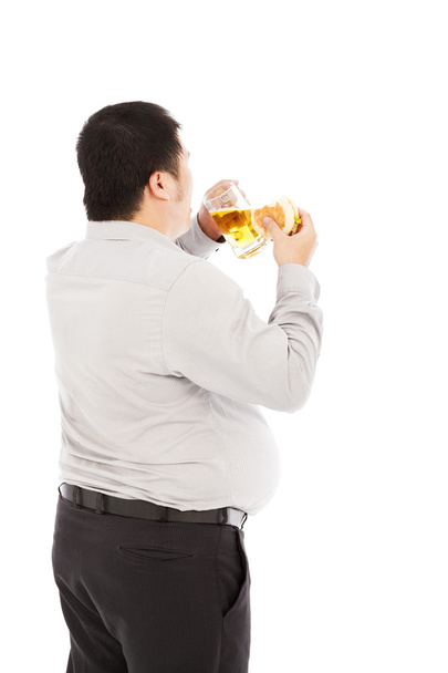 El gordo hombre de negocios está comiendo en exceso. aislado en un blanco
 - Foto, Imagen