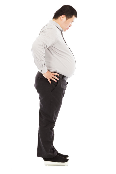 lihava liikemies seisoo painon mittakaavassa
 - Valokuva, kuva