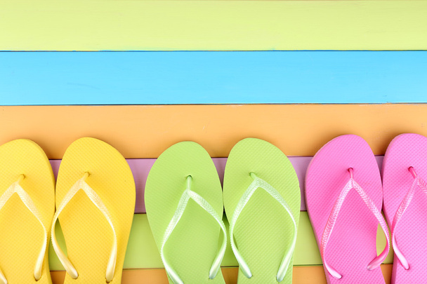 Bright flip-flops on color wooden background - Fotografie, Obrázek