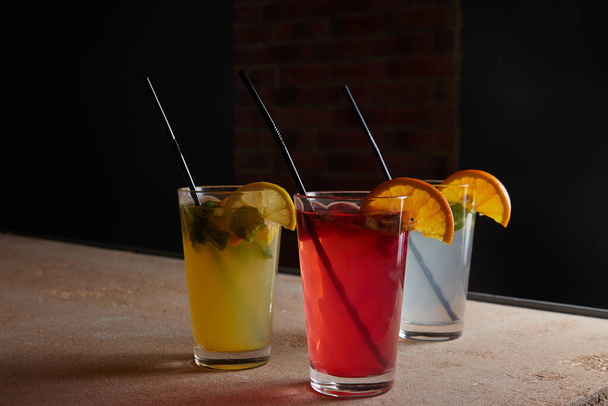 na stole, nealkoholické nápoje, různé koktejly, sklenice se slámou a plátek citronu, rozmazané pozadí - Fotografie, Obrázek