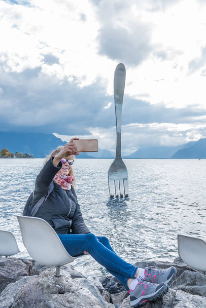 Aikuinen nainen ottaa selfie järven Genevessä, Vevey, Sveitsi. - Valokuva, kuva