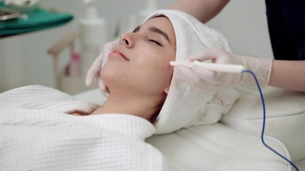 美容クリニック美しい女性が顔を治療してる。美容クリニックの顔の治療皮膚のツールプロセスを使用してクリニックで医師や看護師。医者は顔に化粧手順を実行します. - 映像、動画