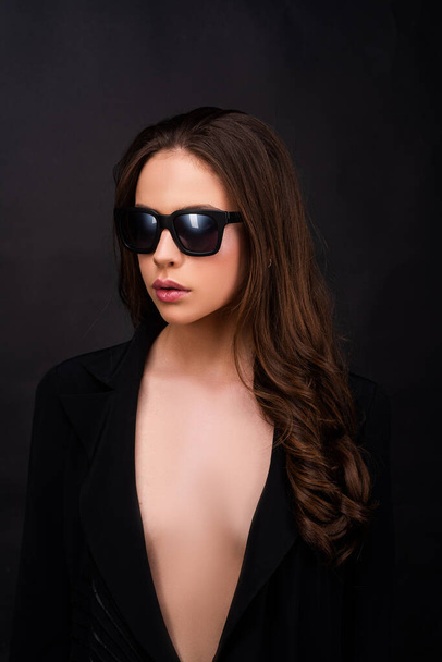 Fashion art studio portrait of beautiful elegant young woman in sunglasses on black. - Valokuva, kuva