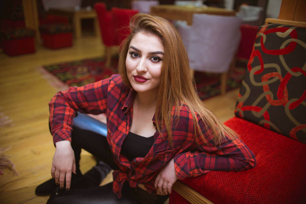 A caucasian young female with a plaid red t-shirt at home - Photo, Image