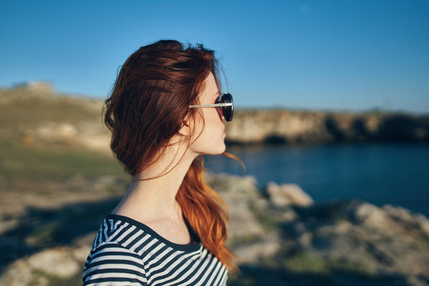 retrato de una mujer en las montañas al aire libre en verano camiseta gafas paisaje - Foto, imagen