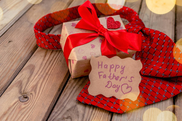 Happy Fathers Day gift craft box with red tie on a rustic wood background. Greeting card - Valokuva, kuva