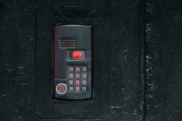 Μια ενδοεπικοινωνία σε παλιά μαύρη βαμμένη επιφάνεια χάλυβα με πληκτρολόγιο, ψηφιακή οθόνη και αισθητήρα rfid για την κλήση close-up - Φωτογραφία, εικόνα