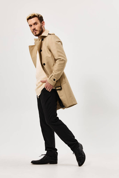 мужчина в бежевом пальто руки в карманах эмоции полный рост - Фото, изображение