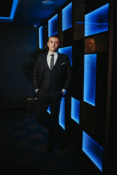 A vertical shot of a handsome Bosnian Caucasian man wearing a suit, posing indoors - Fotó, kép