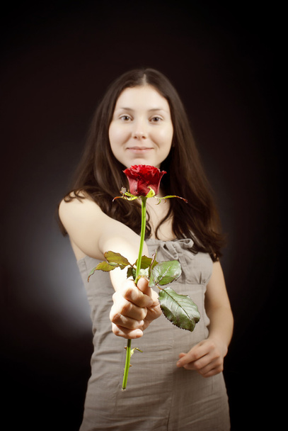 schönes Mädchen in Sarafan gibt eine rote Rose - Foto, Bild