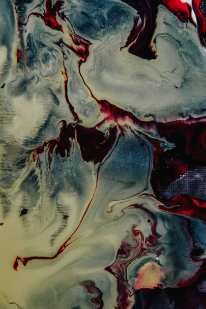 A vertical shot of an abstract painting with mixed red and white oil paint colors - 写真・画像