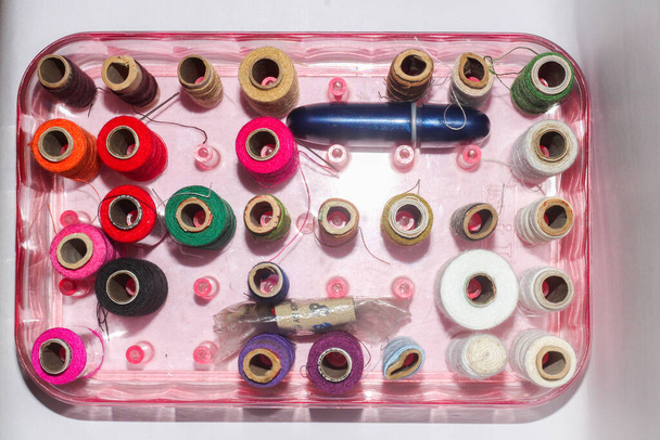 A top view of colorful sewing threads in a box - 写真・画像