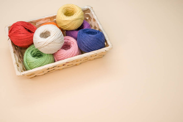 Colorful thread rolls in a box isolated on a beige background - Fotoğraf, Görsel