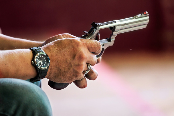 ázsiai ember ellenőrzi a fegyvert  - Fotó, kép
