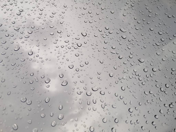 Gotas de lluvia sobre cristales de ventana con fondo nublado. - Foto, imagen