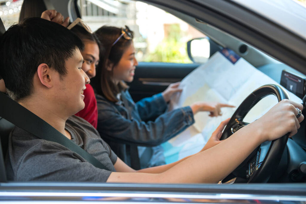 Šťastné asijské mladí přátelé zkontrolovat mapu v autě pro road trip plán během jízdy. Rekreační tvůrce nebo cestovní dovolená v letním konceptu. - Fotografie, Obrázek