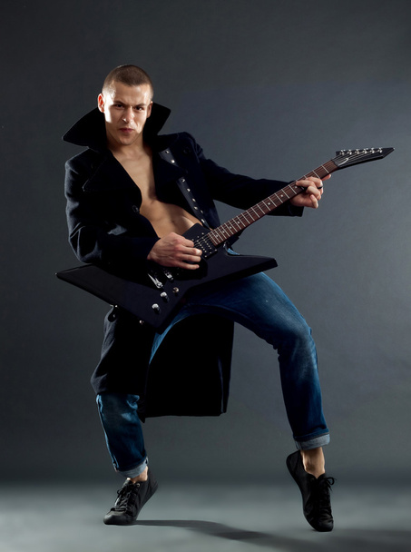 guitarrista apaixonado tocando sua guitarra elétrica no preto
 - Foto, Imagem
