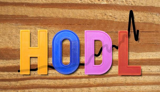 HODL est un terme dérivé d'une mauvaise orthographe de HOLD qui se réfère à acheter et détenir des stratégies dans le contexte du commerce crypto-monnaies, sur fond de texture du bois - Photo, image