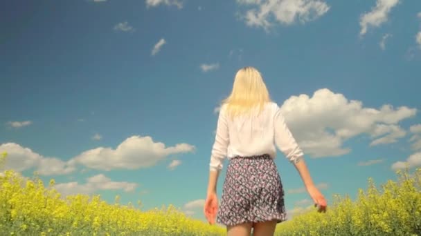 Egy fiatal nő fut keresztül a virágzó repcemagmezőn.. - Felvétel, videó