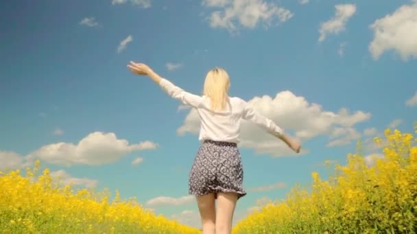 nő fut gyorsan rét virágzó repce, mosolygó, karját kitárt - Felvétel, videó