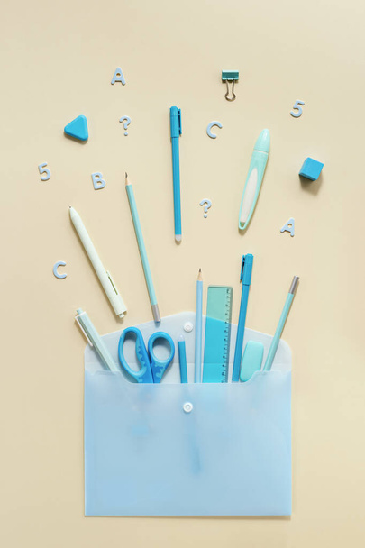 Back to school creative background. Open envelope and school supplies, pencils, pens, rulers, blue and yellow pastel colored. - Фото, зображення