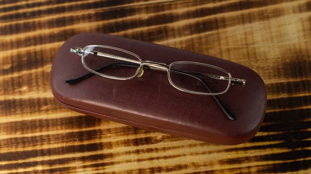 A shot of the eyeglasses with case on a wooden base in a white background. - Valokuva, kuva