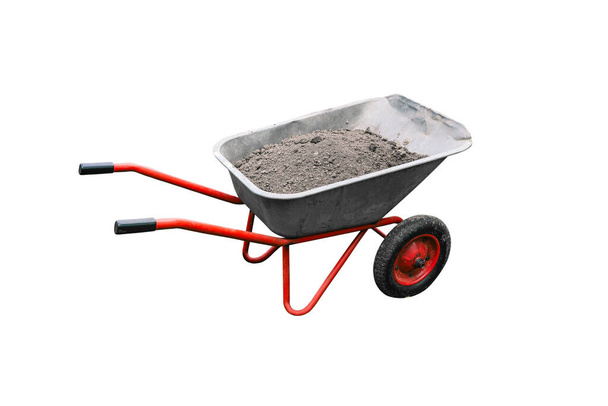 Construction cart with earth isolated on white background. Metal trolley with wheels. A tool for working in a garden or construction site. Gardening or house building concept. - Photo, Image