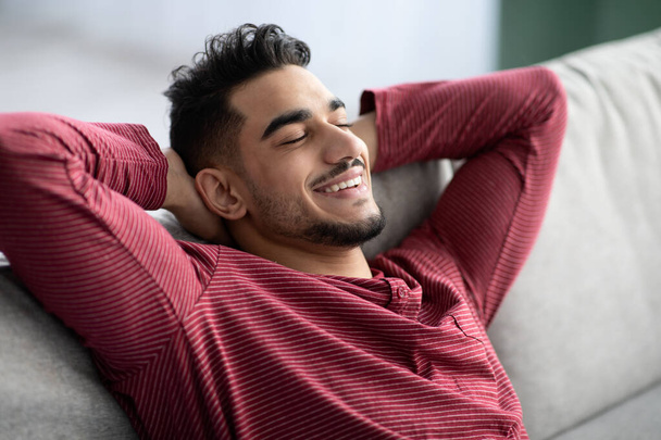 Closeup of peaceful arab guy reclining on couch at home - Фото, зображення