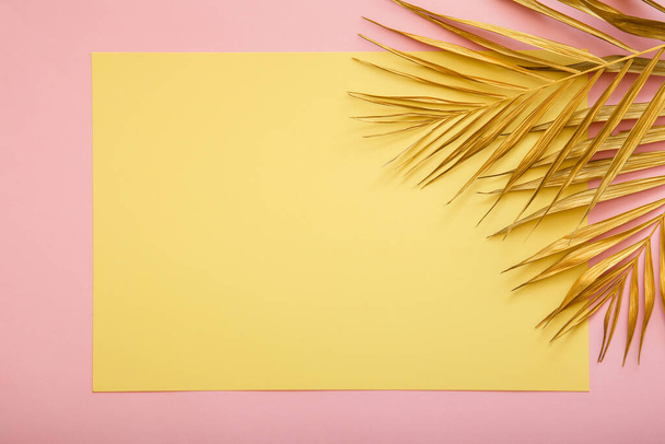 Gele kaart kopiëren ruimte voor tekst in frame gemaakt van gouden palmblad. Tropische palmbladeren op roze achtergrond. Geschilderd goud laat op de zomer bloemige achtergrond. - Foto, afbeelding