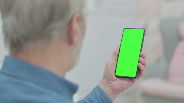 Achteraanzicht van Senior Old Man Kijkend naar Smartphone met Chroma Key Screen - Video