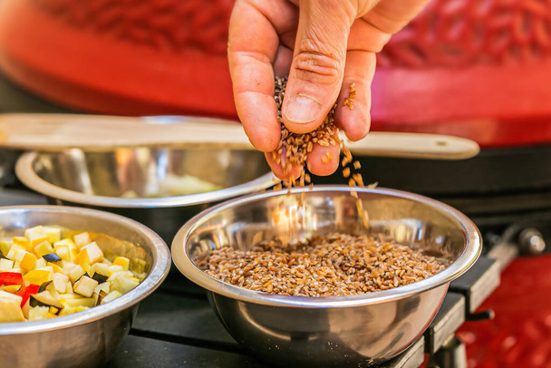 Chef prepares ingredients for bulgur on the grill. Close up - Photo, Image