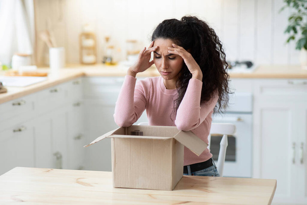 Wrong Item. Frustrated Young Woman Looking At Open Parcel With Despair - Фото, изображение