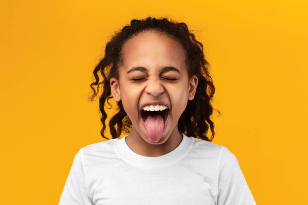 Naughty black teenage girl sticking out her tongue - Photo, Image