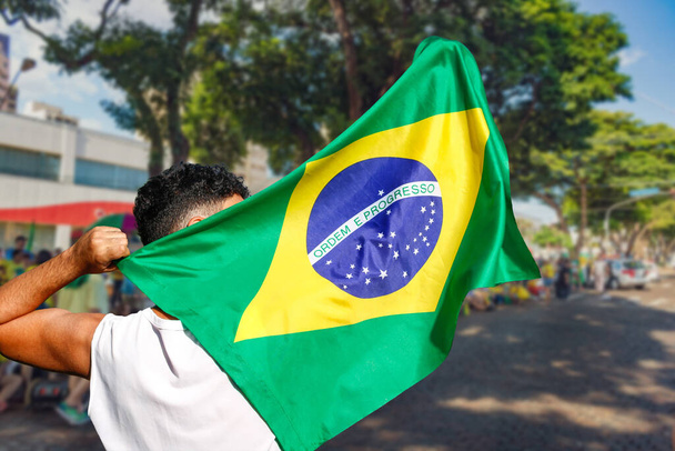 Чоловік тримає прапор на вуличних демонстраціях проти корупції в Бразилії. Демократія Люди зустрічають концепцію фото. - Фото, зображення