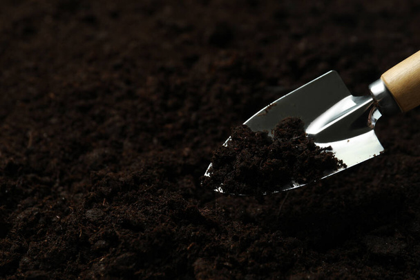 Лопата для садоводства на фоне почвы, место для текста - Фото, изображение