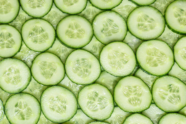 Fresh green slices of cucumber as background. Top view.  - Fotó, kép