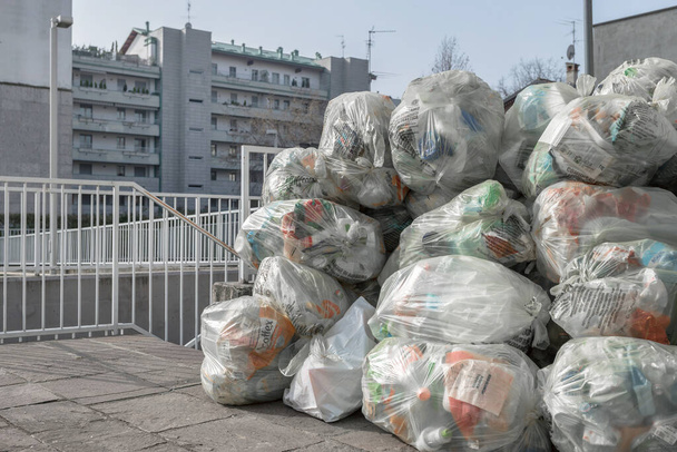 Bolsas de basura en la acera. Bolsas transparentes para la recogida diferenciada de residuos. Bergamo, ITALIA - 23 de febrero de 2021. - Foto, Imagen