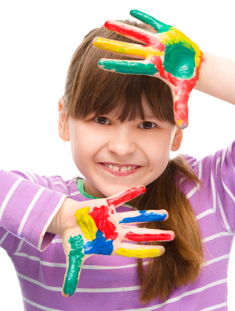 Portrait of a cute girl playing with paints - 写真・画像