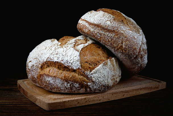 Буханка деревенского хлеба на деревянной доске. Домашний хлеб . - Фото, изображение