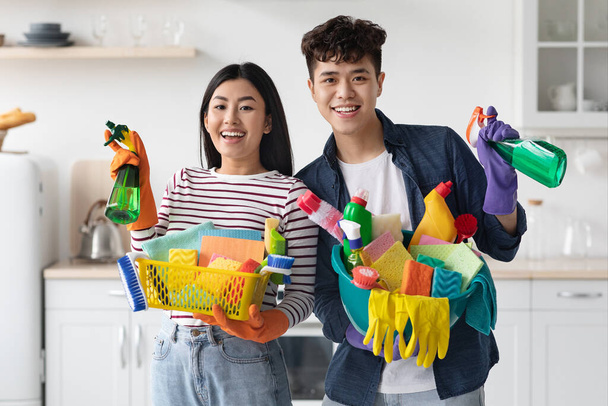 Positivo jovem coreano homem e mulher com suprimentos de limpeza - Foto, Imagem