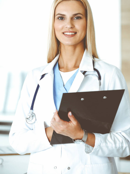Woman-doctor controls medication history record and medical exam results. at black clipboard. Medicine concept - Photo, Image
