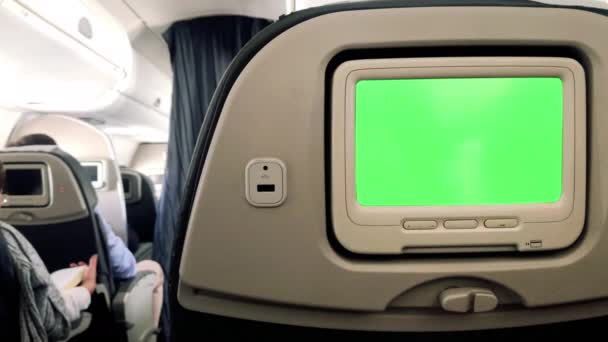 Monitor met groen scherm op passagiersstoel van een vliegtuig. Inzoomen. U kunt het groene scherm vervangen door de beelden of foto die u wilt. U kunt dit doen met Keying effect in After Effects of een andere videobewerkingssoftware (bekijk tutorials). 4K. - Video