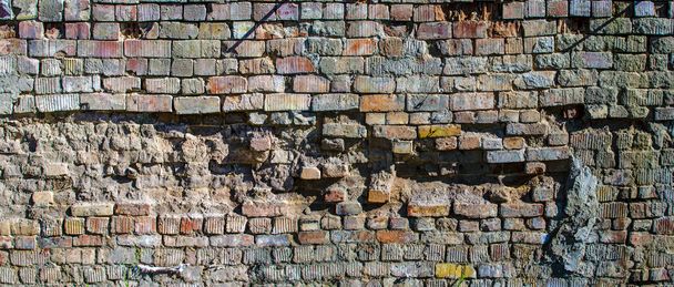 Boş eski tuğla duvar dokusu. Boyanmış duvar yüzeyleri. Şık geniş tuğla. Grange Red Stone arka planı. Hasarlı alçıyla binanın eski püskü yüzü.. - Fotoğraf, Görsel