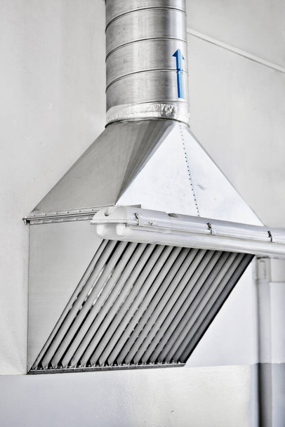 Capucha metálica en la tienda de producción. Instalación de un sistema de ventilación en locales industriales - Foto, Imagen