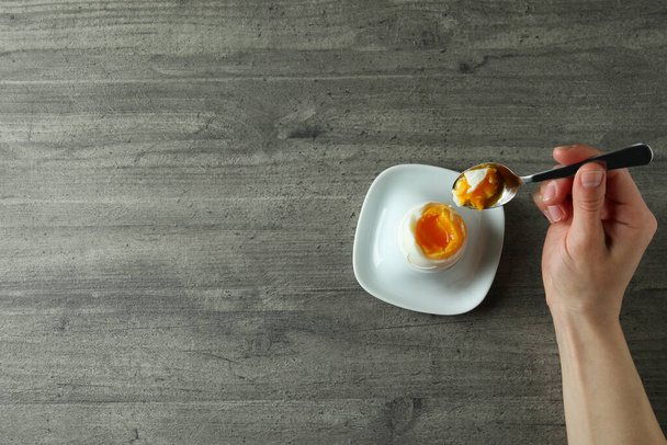 Concepto de sabroso desayuno con huevo cocido sobre fondo texturizado gris - Foto, Imagen