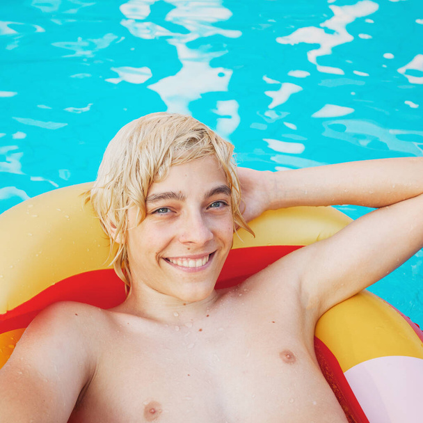 Handsome in the pool outdoor. Happy teen boy at summer holiday - Φωτογραφία, εικόνα